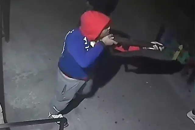 Image of the suspect holding a long firearm